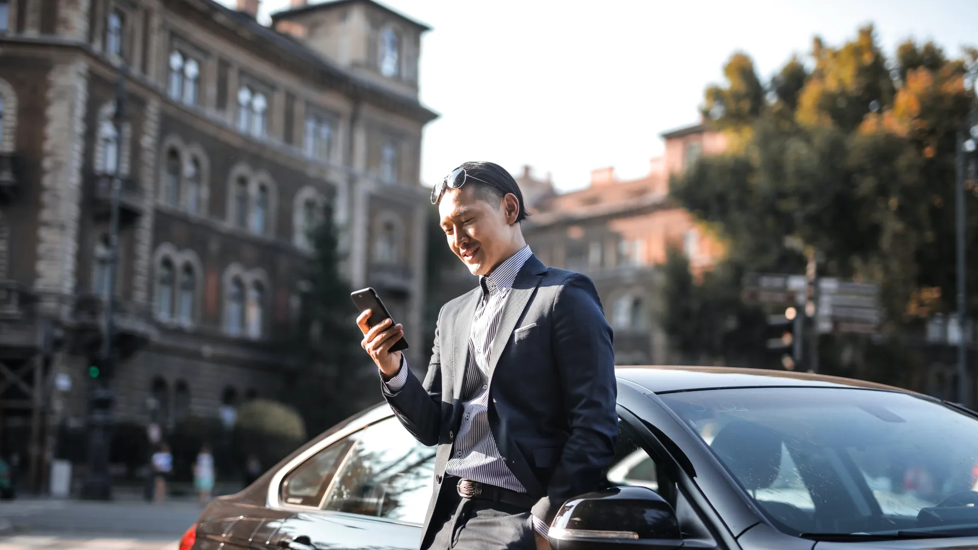 Man standing next to a car using a phone